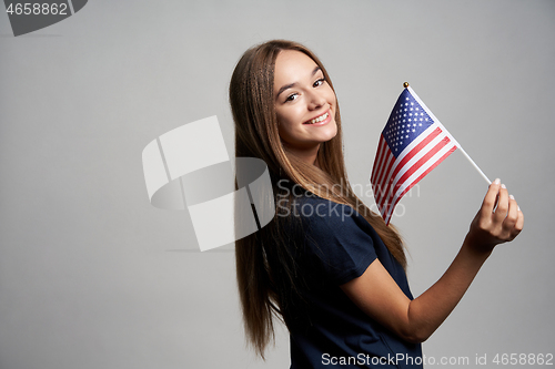 Image of Happy female holding United States flag