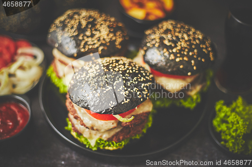 Image of Black double burgers with vegetables and cheese