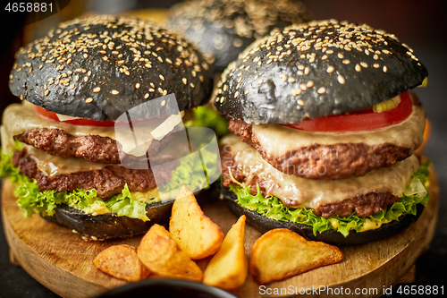 Image of Appetizing black hamburgers and fried potato