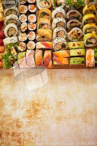 Image of Wooden board with assortment of various kinds of sushi rolls. Japanese food concept