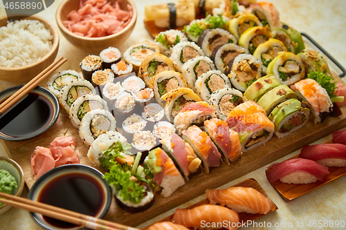 Image of Above view of various sushi and rolls placed on wooden board. Japanese food fest