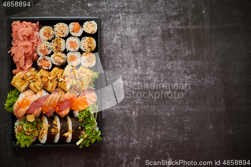 Image of Sushi take-away plastic tray with diffent kinds of rolls and copy space. Take-away food concept.