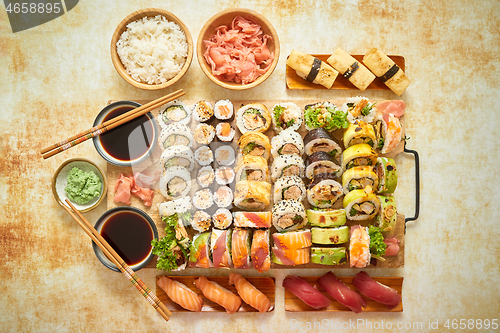 Image of Top view background with set of colorful different kinds of sushi rolls placed on wooden board