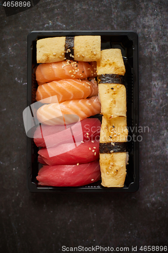 Image of Nigiri sushi set in plastic container ready for takeout delivery. Closeup of take away lunch box