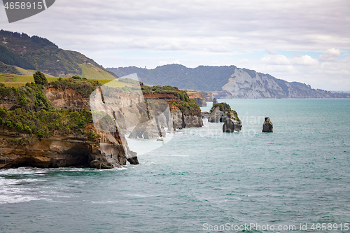 Image of sea shore rocks and mount Taranaki, New Zealand