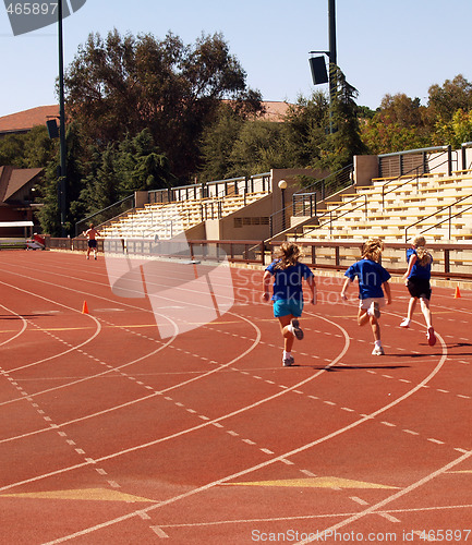 Image of three young girls running on track sprinting competition