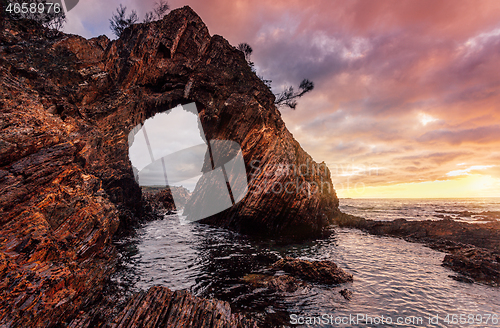 Image of Morning sunrise at dramatic sea arch cave