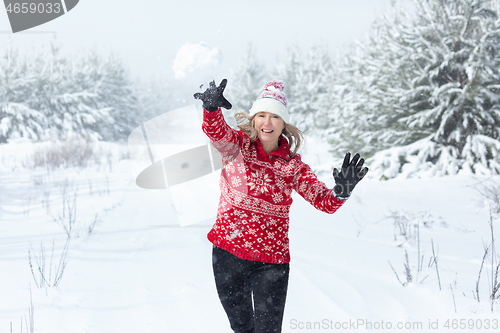 Image of Playful woman throwing a snowball