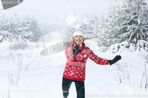Image of Snowball flying through the air as it leaves womans hands