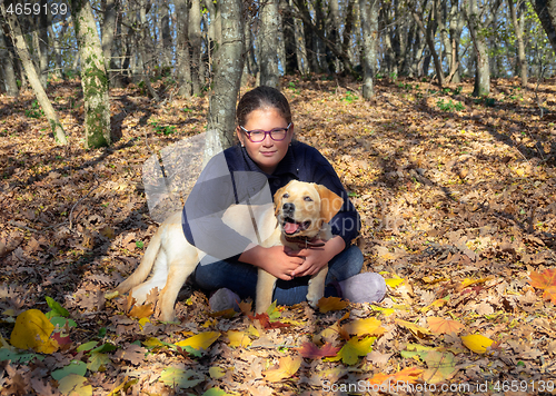 Image of Portrait of girl with dog in autumn forest