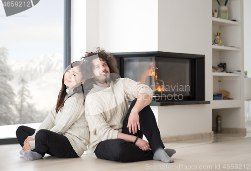 Image of happy multiethnic couple  in front of fireplace