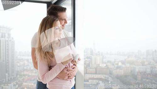 Image of young couple enjoying morning coffee by the window