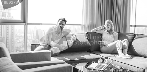 Image of couple relaxing at  home using tablet computer