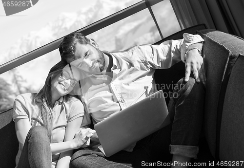 Image of couple relaxing at  home using laptop computers