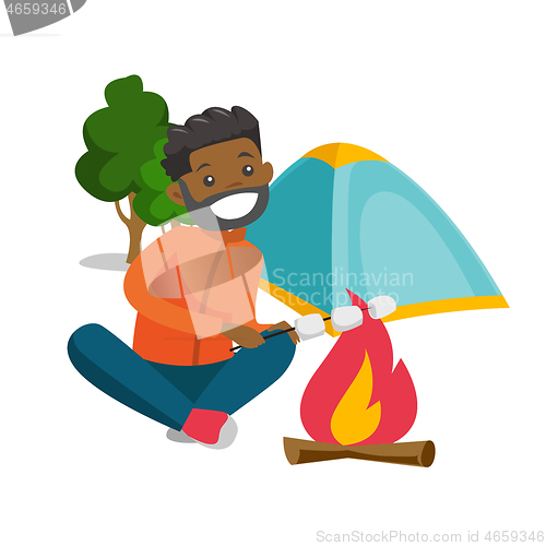Image of African man roasting marshmallow over campfire.