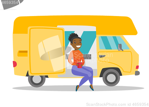 Image of Young african woman drinking coffee in motorhome.