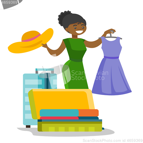 Image of African-american woman packing clothes in suitcase