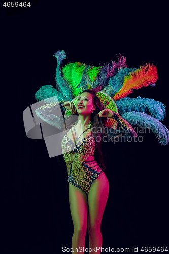 Image of Beautiful young woman in carnival peacock costume