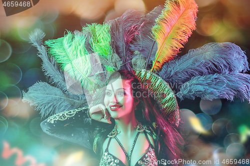 Image of Beautiful young woman in carnival peacock costume