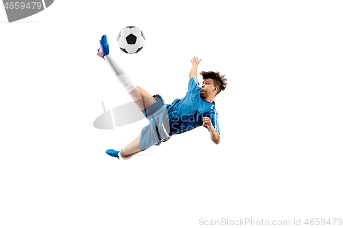 Image of Young boy with soccer ball doing flying kick