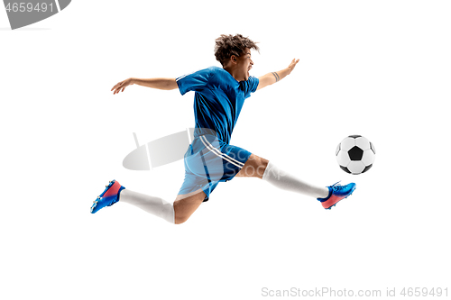 Image of Young boy with soccer ball doing flying kick