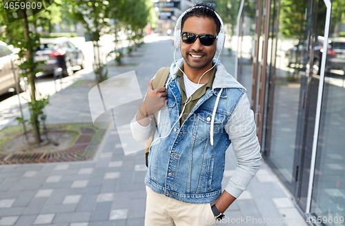 Image of indian man in headphones with backpack in city