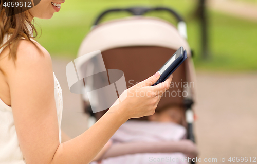 Image of mother with stroller reading internet book at park
