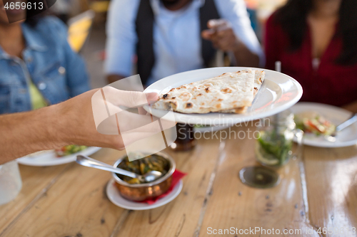 Image of international friends eating at restaurant