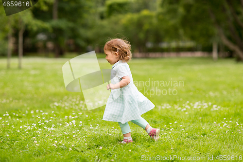 Image of happy little baby girl running at park in summer