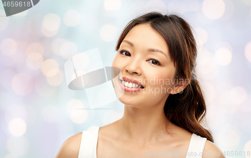 Image of face of happy smiling young asian woman