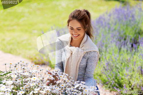 Image of young woman with flowers at summer garden