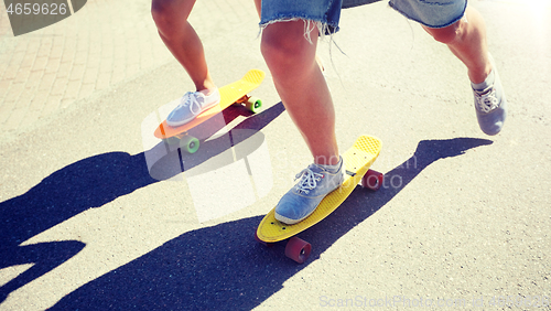 Image of teenage couple riding skateboards on city road