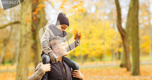 Image of happy family having fun in autumn park