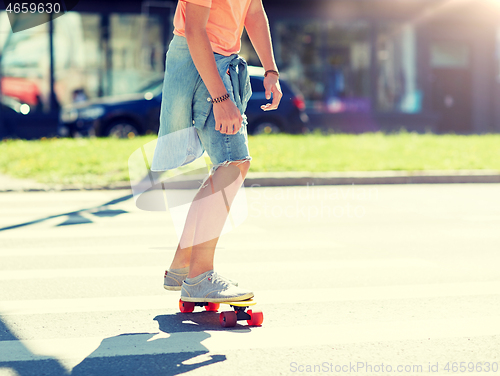 Image of teenage boy on skateboard crossing city crosswalk