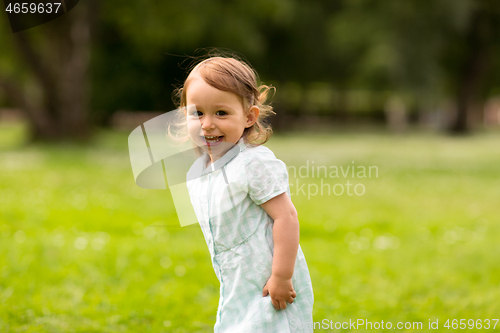 Image of happy little baby girl at park in summer