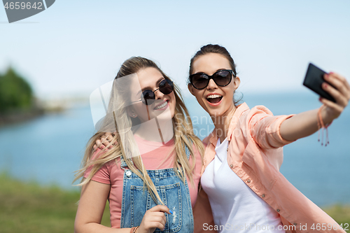 Image of teenage girls or friends taking selfie in summer