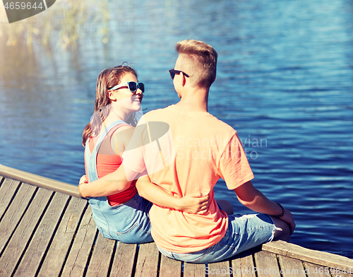 Image of happy teenage couple hugging on river berth