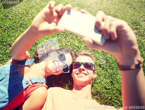 Image of happy couple taking selfie on smartphone at summer