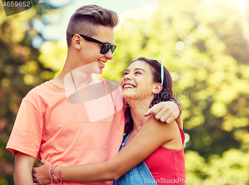 Image of happy teenage couple looking at each other in park