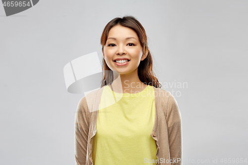 Image of happy asian woman over grey background