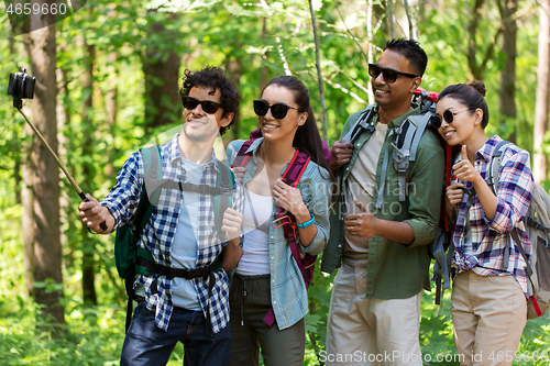 Image of friends with backpacks hiking and taking selfie