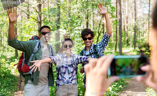Image of friends with backpacks being photographed on hike