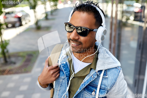 Image of indian man in headphones with backpack in city