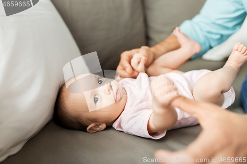 Image of middle aged father playing with baby at home