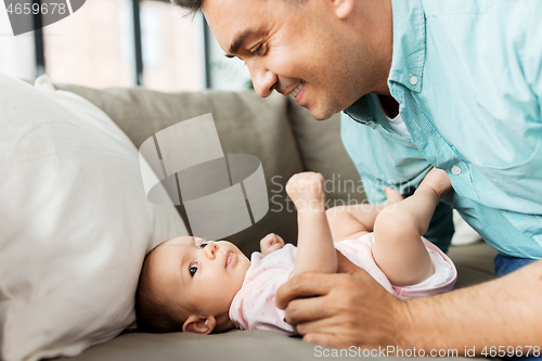 Image of middle aged father playing with baby at home