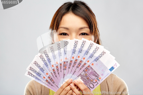 Image of asian woman with hundreds of euro money banknotes