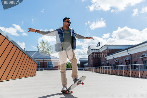 Image of indian man doing trick on skateboard on roof top