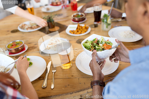 Image of international friends eating at restaurant