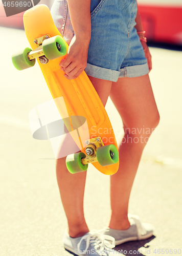 Image of teenage girl with skateboard on city street