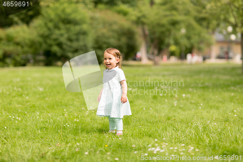 Image of happy little baby girl at park in summer